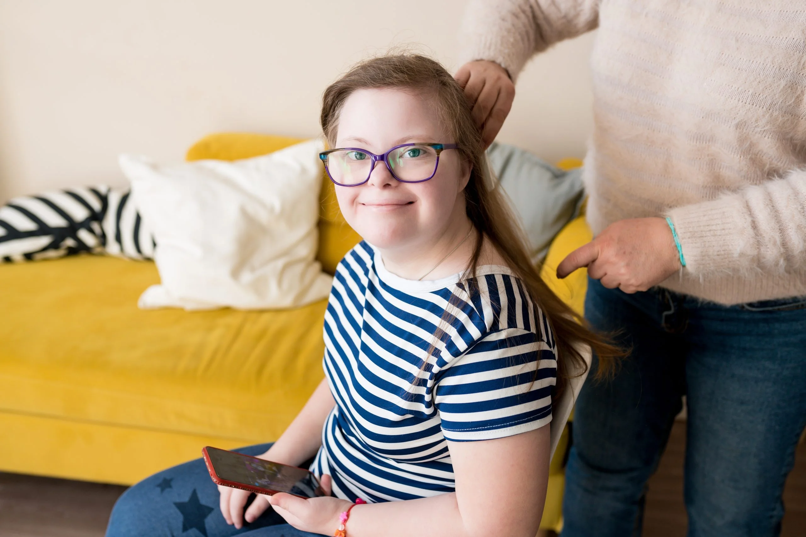 Sfeerbeeld: een ouder helpt haar dochter bij de dagelijkse verzorging thuis.